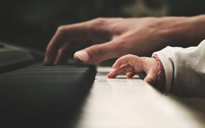 Imágen de las manos de un adulto y un niño tocando un piano Imágen de las manos de un adulto y un niño tocando un piano